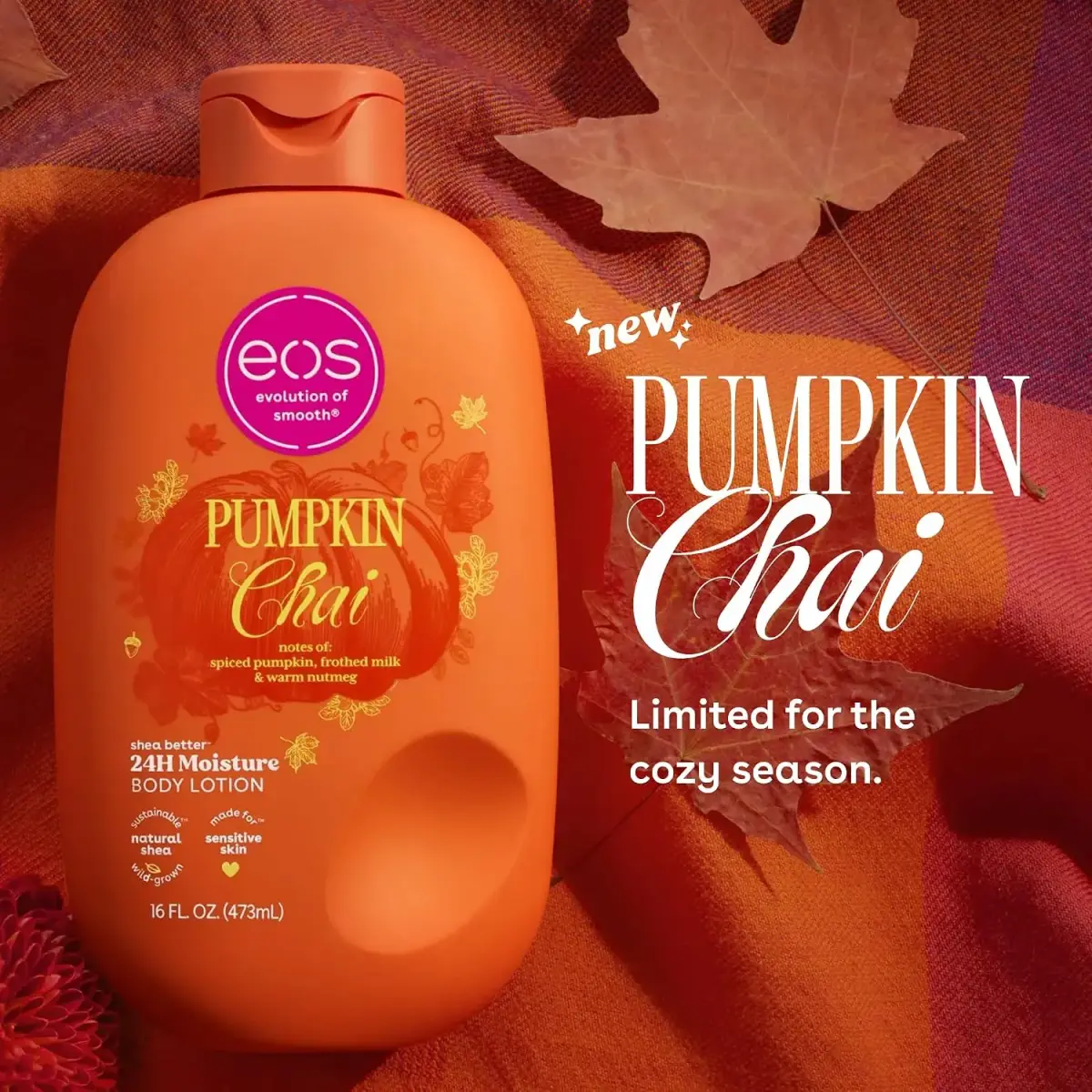 Orange eos Pumpkin Chai 24H Moisture Body Lotion bottle on autumn fabric with leaves; “new Pumpkin Chai” ad evokes a cozy seasonal mood.